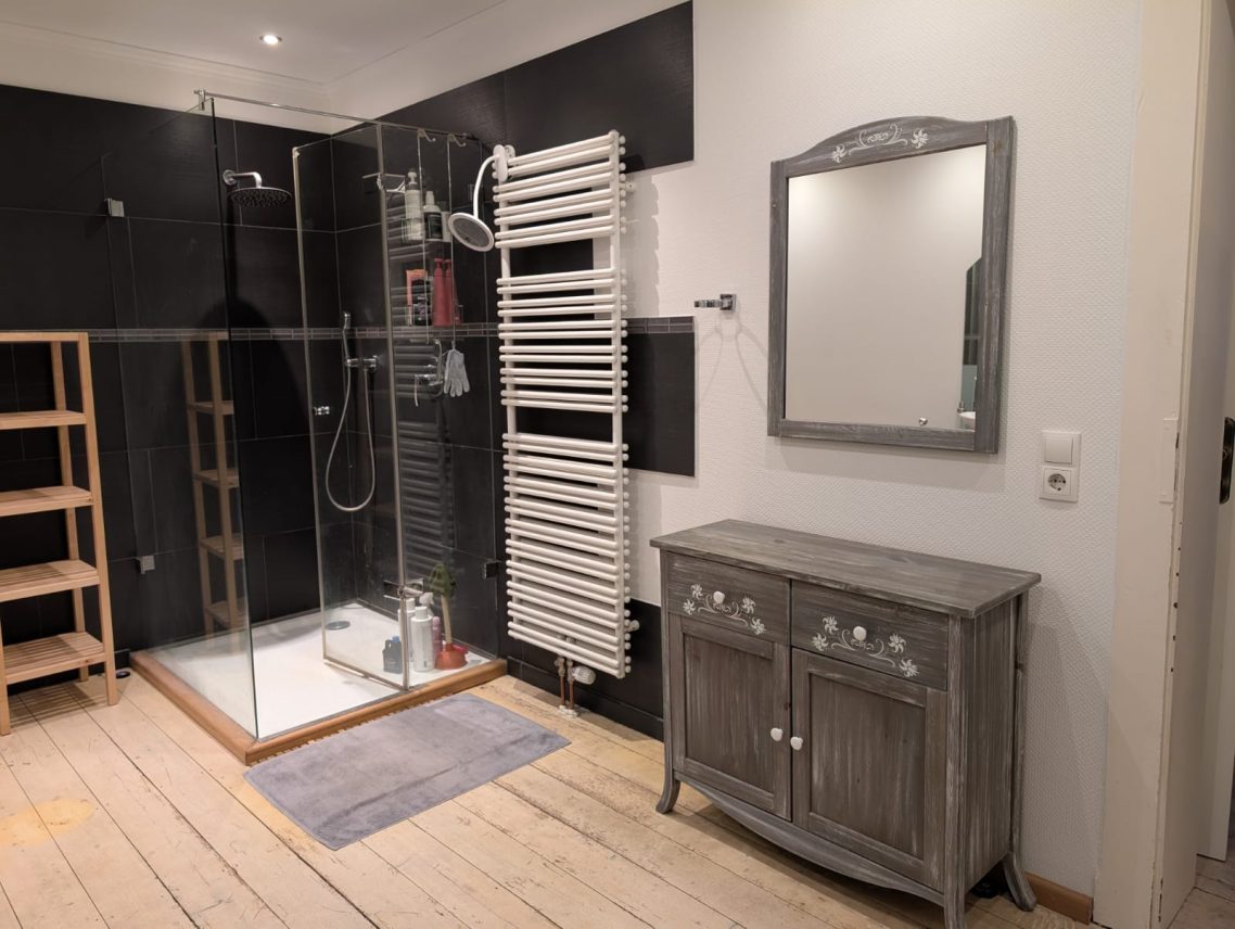 großes Waschbecken Dusche Modernes Badezimmer mit Dusche, Waschbecken, Spiegel und Handtuchheizung an der Wand.